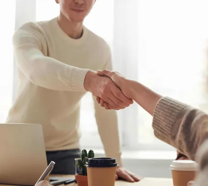 Two professionals shaking hands, symbolizing successful collaboration and partnership in custom software solutions with our expert software development company.